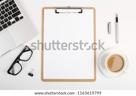 Workspace with blank clip board, laptop keyboard, office supplies, pen, glasses and coffee cup on white background. Flat lay, top view office table desk. Royalty-Free Stock Photo #1163619799