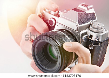 Retro SLR camera in the hands of the photographer closeup