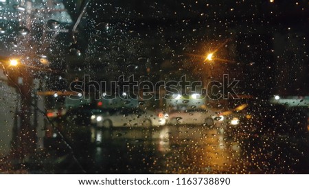 The rain drops on the windows of cars on heavy rains and traffic jams.
