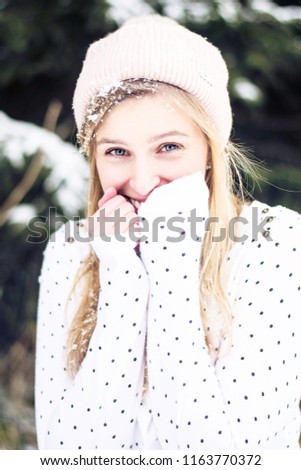 Young beautiful woman having a good time in winter forest.