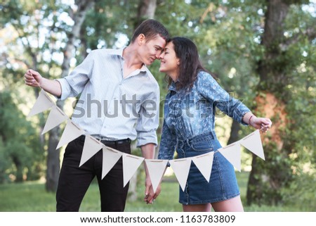 young couple posing with flags in the forest, summer nature, romantic feelings