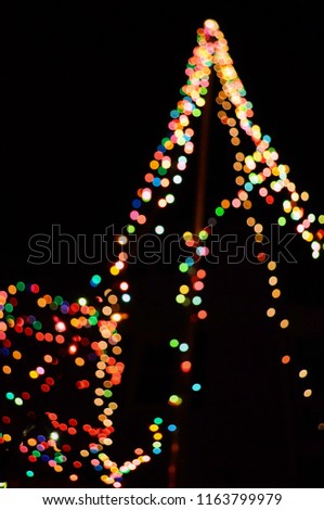 Several colors of blurry lights decorated all over a Christmas tree with a dark black background.
Different colors different feelings and emotions.