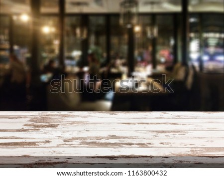 Wooden table with blured background cafe , for your photo montage or product display. Space for placing items on the table.