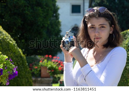 Young teen ager girl shooting pictures with a vintage camera while on vacation in Italy