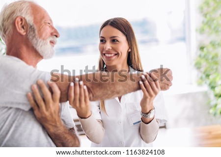 Man having chiropractic arm adjustment. Physiotherapy, sport injury rehabilitation. Senior man exercises in center for chiropractic. Royalty-Free Stock Photo #1163824108