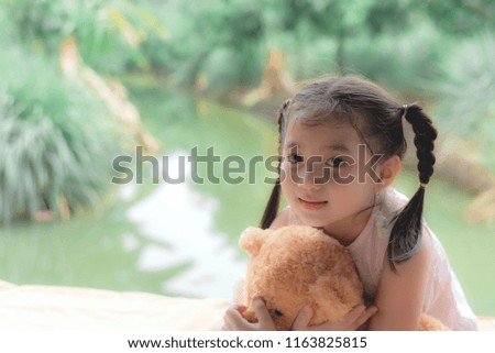 Cute child huging her brown teddy bear
