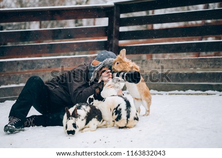 Photographer having fun and taking pictures in a rabbit park in winter. 