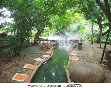 Beautiful and Shady  foot soak onsen, at Mae Khachan Hot Spring in Mae Khachan district, Chiang Rai, Thailand  Royalty-Free Stock Photo #1163837701