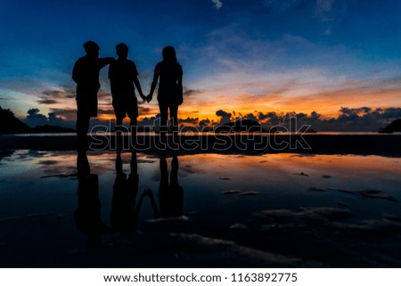 Silhouette of young people in friendship over the sunset views at the beach
