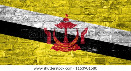 Flag of Brunei over an old brick wall background, surface.
