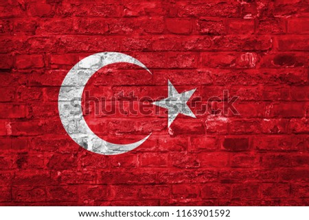 Flag of Turkey over an old brick wall background, surface.