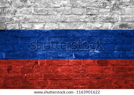 Flag of Russia over an old brick wall background, surface.
