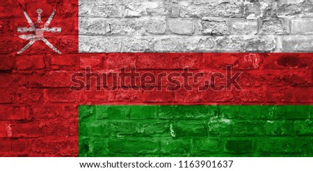 Flag of Oman over an old brick wall background, surface.