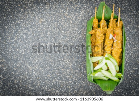 close up pictures barbecue pork with cucumber in banana leaves with space