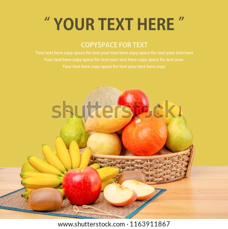 Composition with assorted fruits in wicker basket on wooden table, copy space
