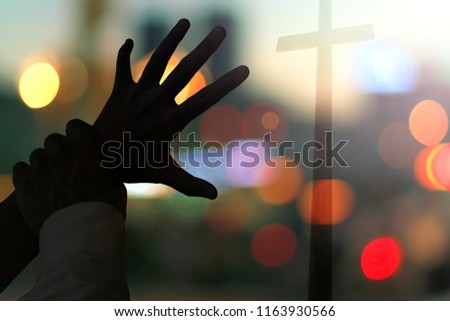 Halloween concept: scary hands stop people from looking for the cross

