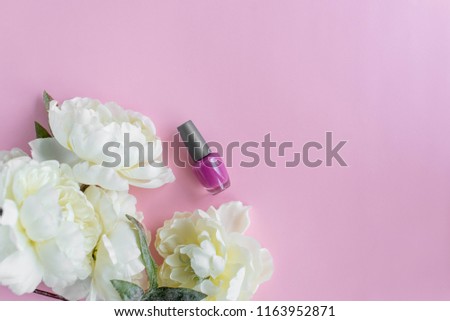 Pink background with white peonies and nail polish on the side. Copy space Royalty-Free Stock Photo #1163952871