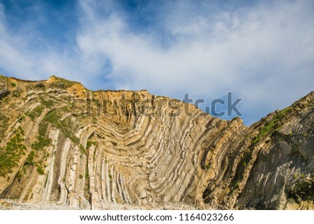 Limestone Foldings on Stair Hole Chalk Cliffs and Blue Sky Royalty-Free Stock Photo #1164023266