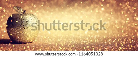 Rosh hashanah (jewish New Year holiday) concept. Traditional symbol, decorative glitter gold apple Royalty-Free Stock Photo #1164051028