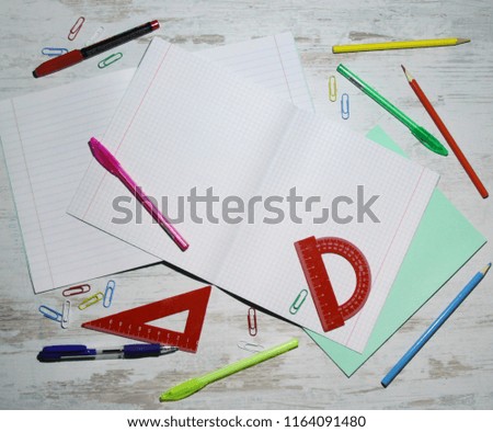 school supplies on light wooden surface, pencils, pens, notebooks, rulers, paper clips