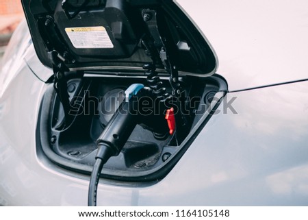 EV Car or Electric car at charging station with the power cable supply plugged in. Royalty-Free Stock Photo #1164105148