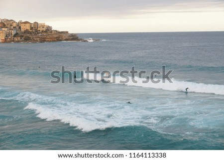 Surfers enjoying a sunny day with good surfing waves at Bondi Beach, Sydney, Australia