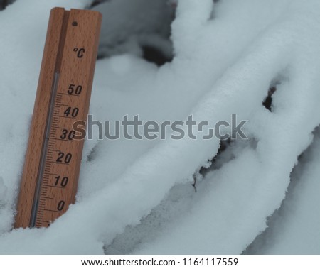 Wooden thermometer on snow background, winter pictures