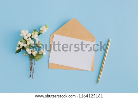 Mockup blank paper card and envelope on a blue background. Flat lay, top view