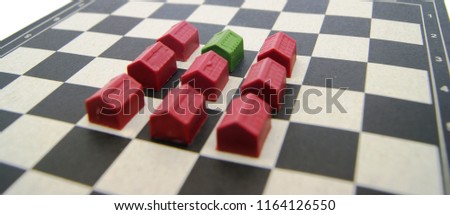 green and red house miniatures on a chessboard. real estate competition strategy