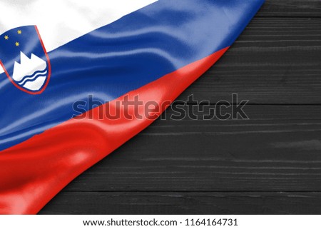 Flag of Slovenia and place for text on a dark wooden background