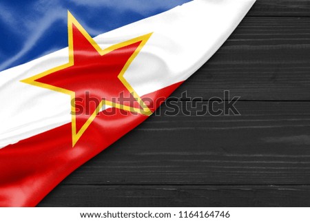 Flag of Yugoslavia and place for text on a dark wooden background