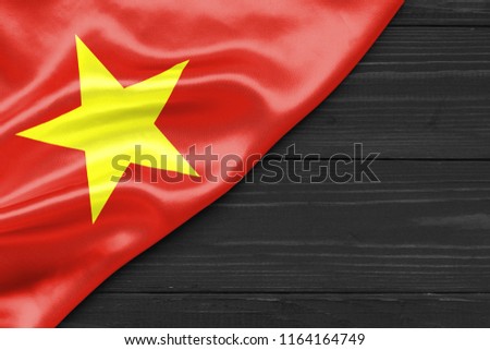 Flag of Vietnam and place for text on a dark wooden background