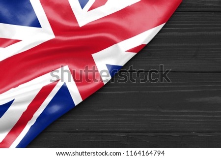 Flag of the United Kingdom and place for text on a dark wooden background