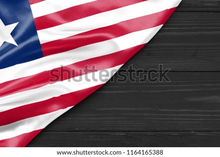 Flag of Liberia and place for text on a dark wooden background