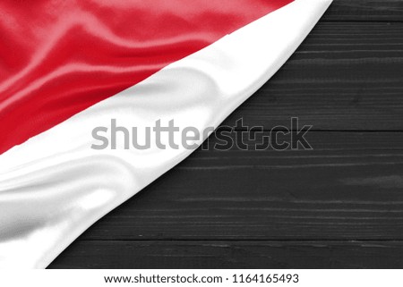 Flag of Monaco and place for text on a dark wooden background