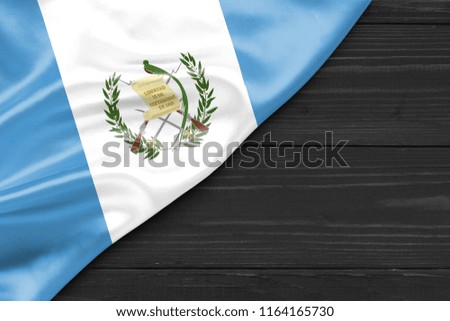 Flag of Guatemala and place for text on a dark wooden background
