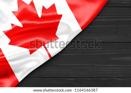 Flag of Canada and place for text on a dark wooden background