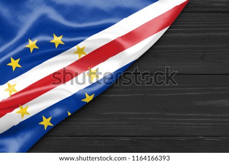 The flag of Cabo Verde and the place for text on a dark wooden background