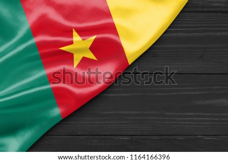 Flag of Cameroon and place for text on a dark wooden background