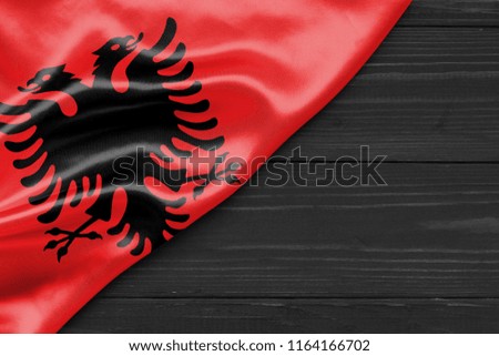 Flag of Albania and place for text on a dark wooden background