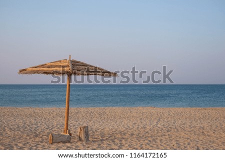 Awning from the sun on the beach at dawn, on an empty beach