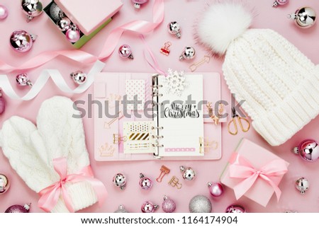 Warm winter clothes and Christmas decor. Arrangement in pastel pink colors.
