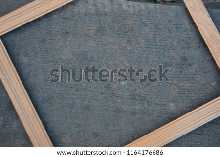 Yellow wooden frame for photos of white wood on a wooden background of a black deck with its own structure
