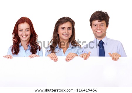 Two smiling attractive businesswomen with handsome businessman holding white board, isolated on white