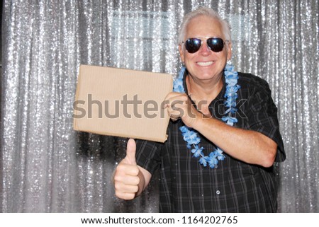 man with blank sign. A Man in a Photo Booth with a Blank Sign. Room for text. Silver sequin background photo booth. 