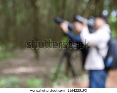 Abstract blurred image of a man taking photo at a park, blur using a camera.