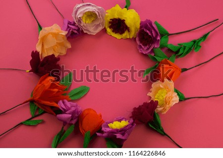 Utensils and tools for making crepe paper flowers on pink background. Cosmos flower bouquet