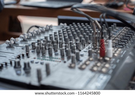 Someone hand working on Volume slide audio mixer in the control room of television broadcast. Mixdown