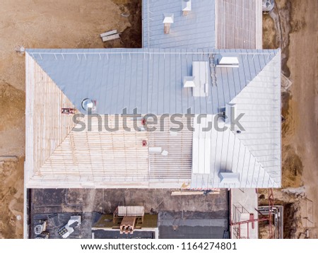 new metal roof construction on a residential house. aerial view of urban building site