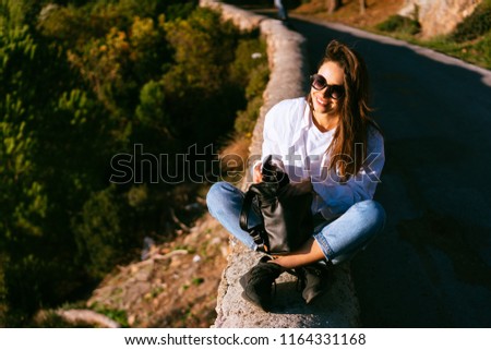 beautiful young girl resting on the nature near the road
